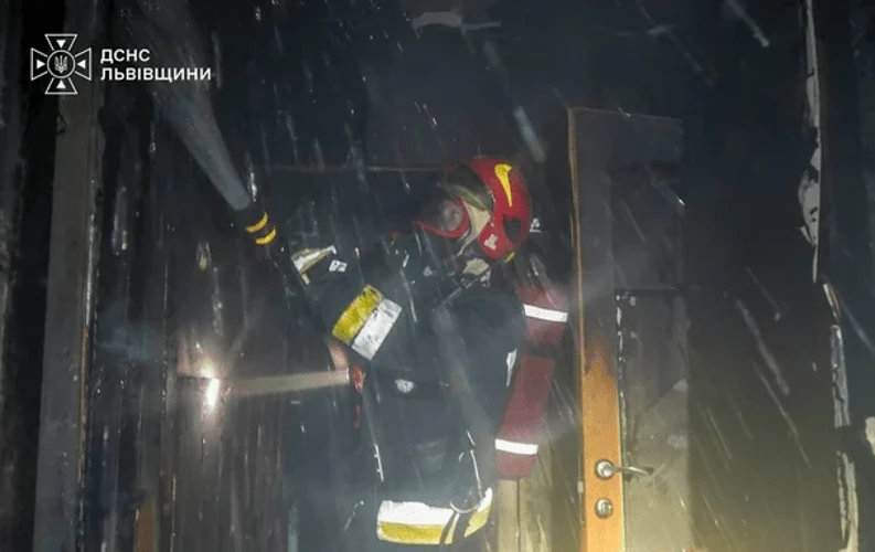 Наслідки пожежі у львівській багатоповерхівці: зруйнована стіна між квартирами, рятувальники з висувною драбиною біля вікон.
