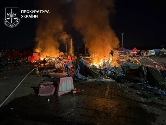 Наслідки влучання на території ринку «Столичний»: пошкоджені будівлі, рятувальники на місці події.